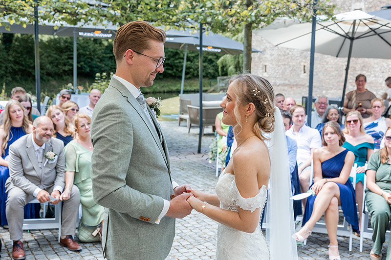 Uitwisseling van geloften tijdens buiten ceremonie bij Kasteel Erestein, ontspannen documentaire trouwfotografie